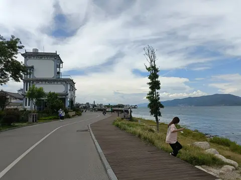 Lakeside path of the Erhai ecological corridor with hills beyond