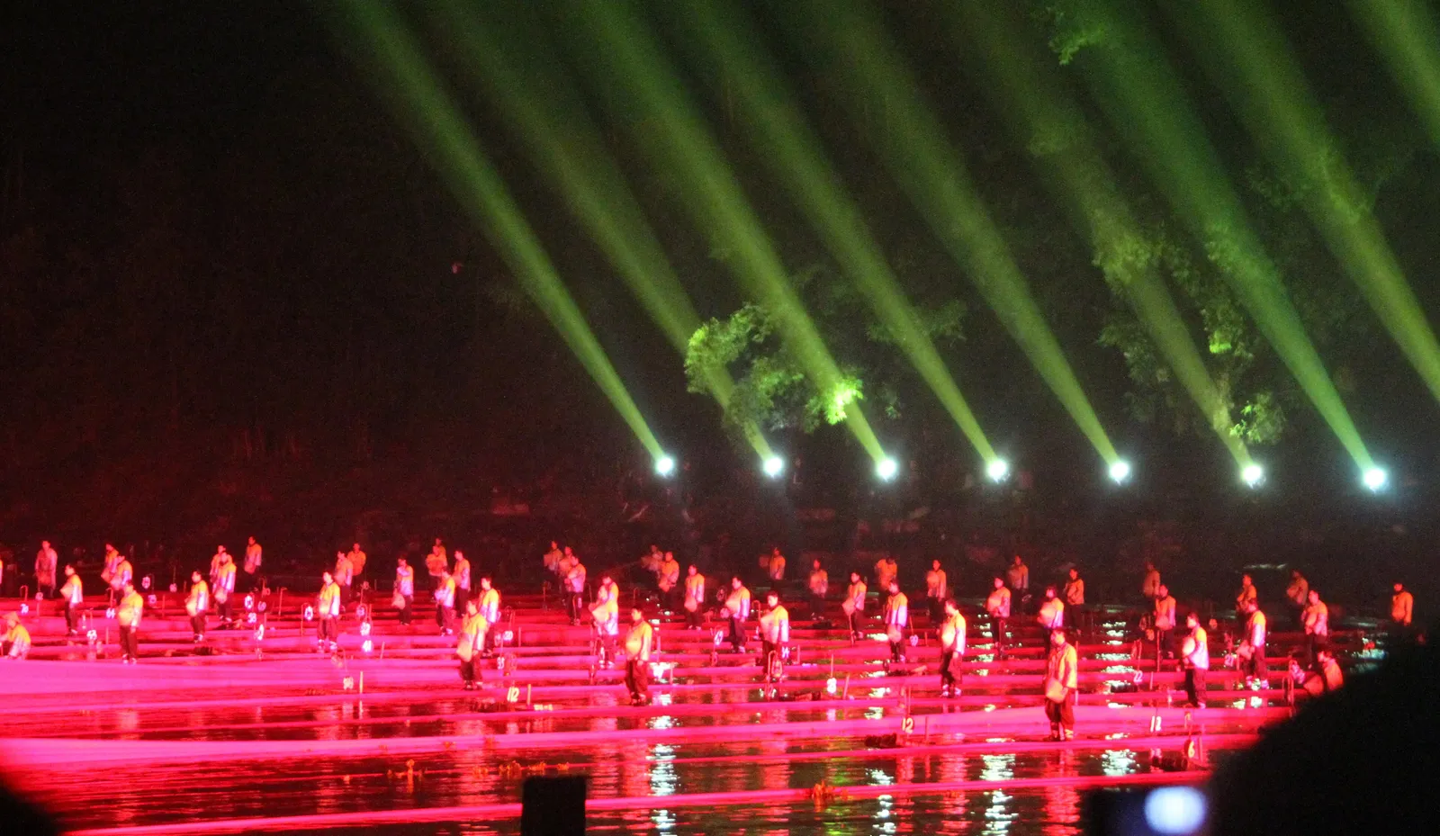 Impression Liu Sanjie: performers on the Li River lit by green beams at night