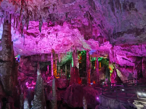 Stalactites and stalagmites under coloured lights in the Jiuxiang Caves