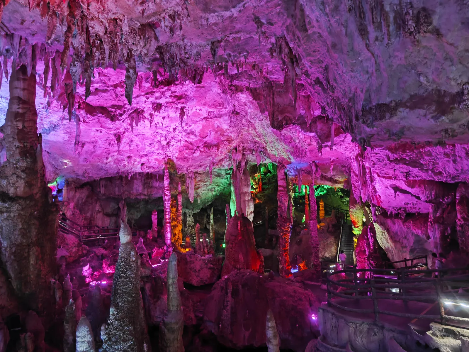 Stalactites and stalagmites under coloured lights in the Jiuxiang Caves