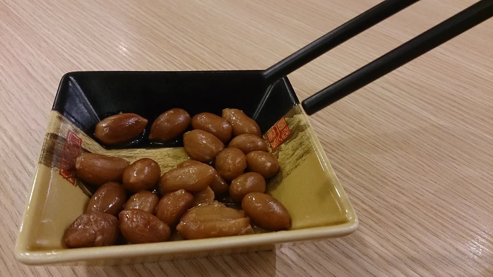 Plato de cacahuetes con palillos en un restaurante chino