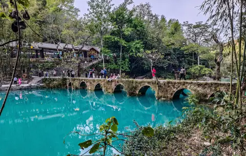 The old seven-arch stone bridge over turquoise water at Xiaoqikong, Libo