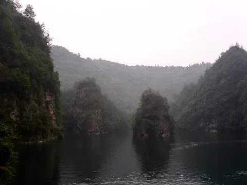 Baofeng Lake’s still water between steep forested cliffs