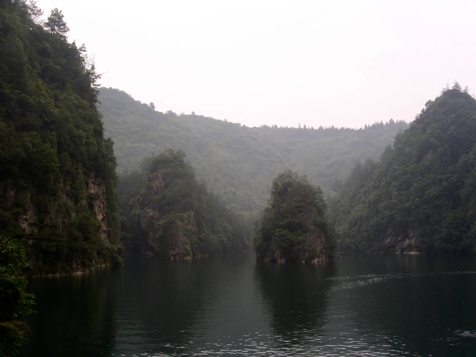 Baofeng Lake’s still water between steep forested cliffs