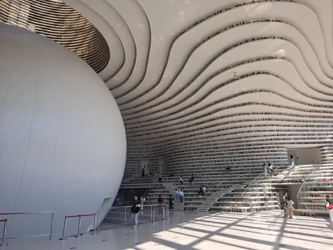 Wave-like terraced bookshelves around the spherical ‘Eye’ in Binhai Library