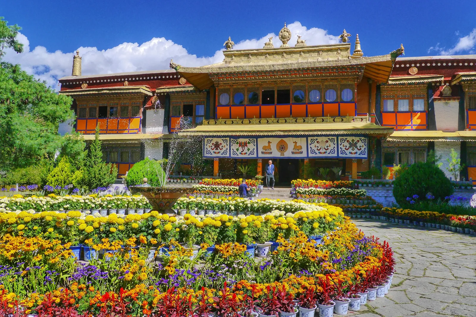 A palace in Norbulingka behind beds of bright flowers