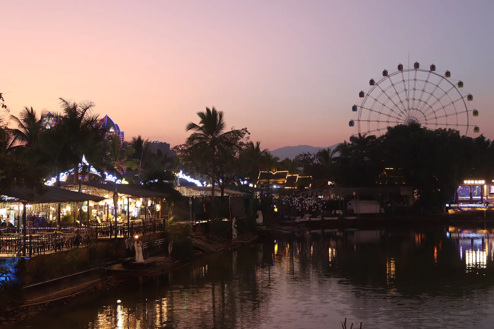 Gaozhuang's riverside night market lit up at dusk with a Ferris wheel
