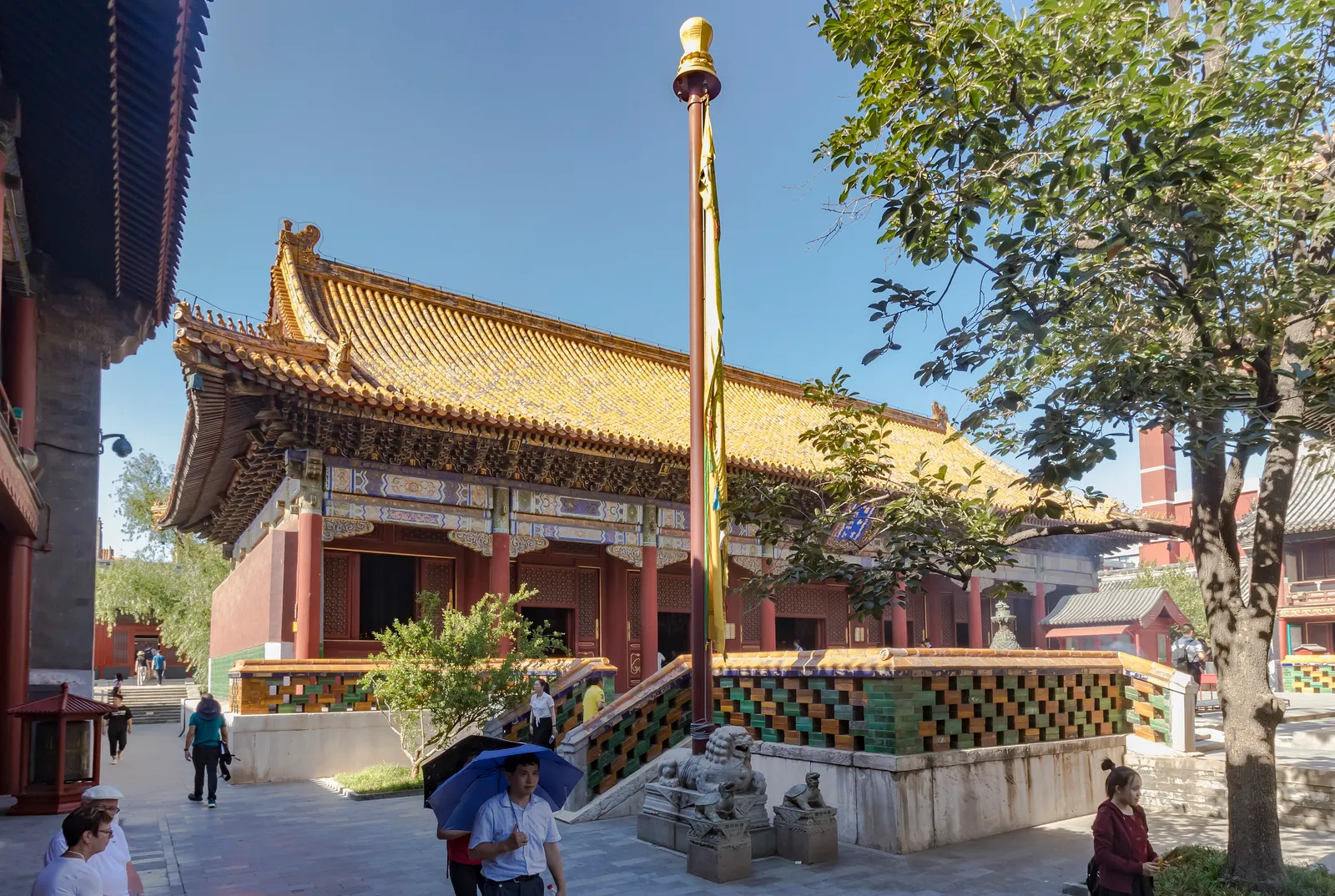 Yellow-roofed hall and prayer pole in a courtyard of the Lama Temple