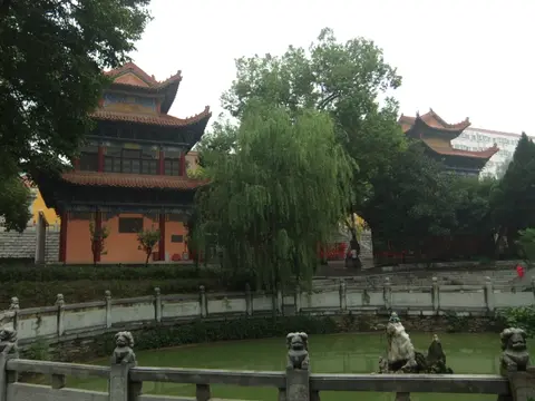 Pagoda-roofed halls of Baotong Temple beside its pond