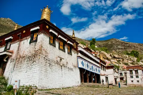 Whitewashed halls with a golden roof at Sera Monastery