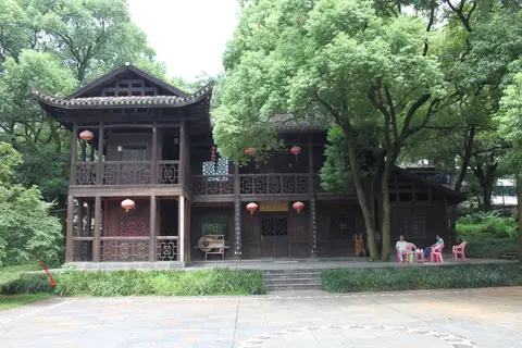 A traditional wooden pavilion among old trees in Hunan Martyrs Park