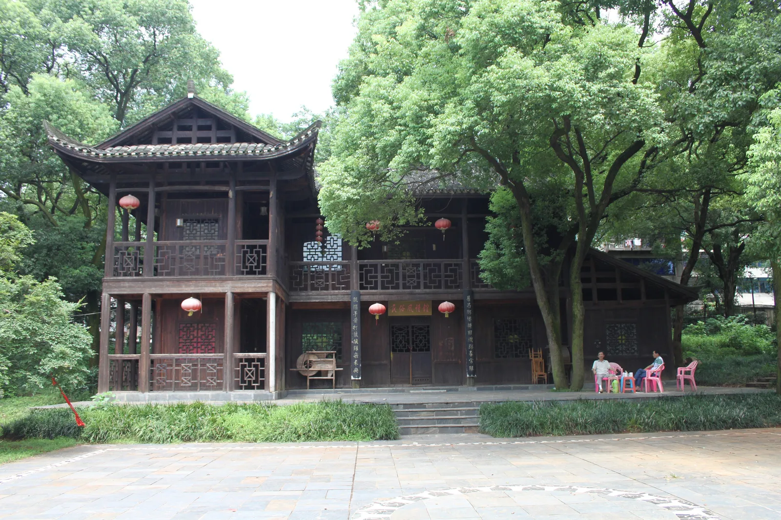 A traditional wooden pavilion among old trees in Hunan Martyrs Park