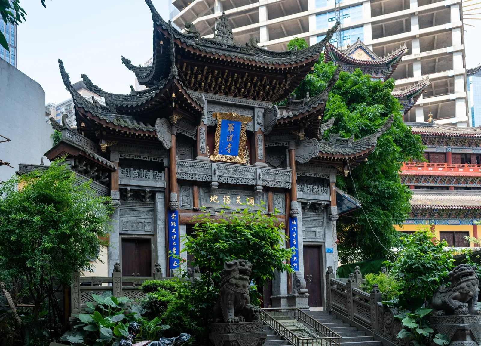 Carved gate tower of Luohan Temple among downtown Chongqing high-rises