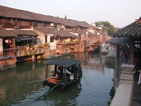 Wooden houses and a boat on a canal in Wuzhen water town