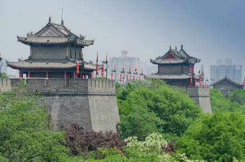 Gate towers on Xi'an's Ming-dynasty city wall above green trees