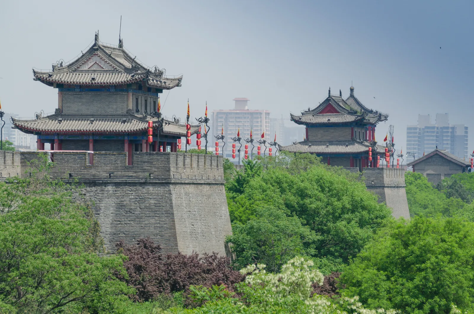 Gate towers on Xi'an's Ming-dynasty city wall above green trees
