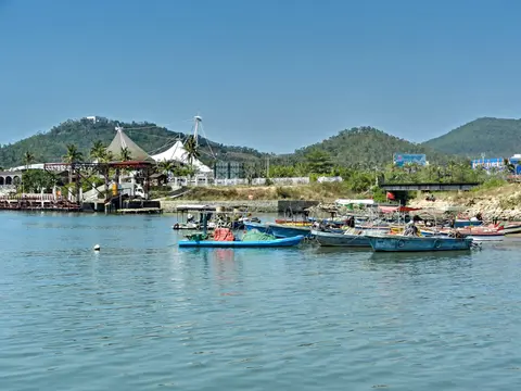 Fishing boats in the harbour of West Island (Xidao) with its green hills
