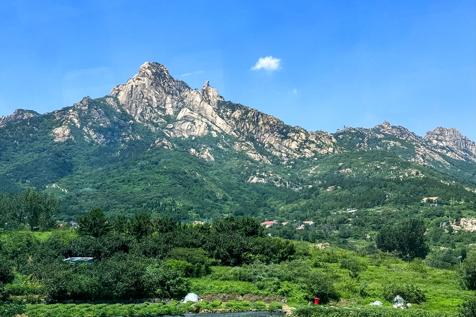 Granite peaks of Laoshan above green hills
