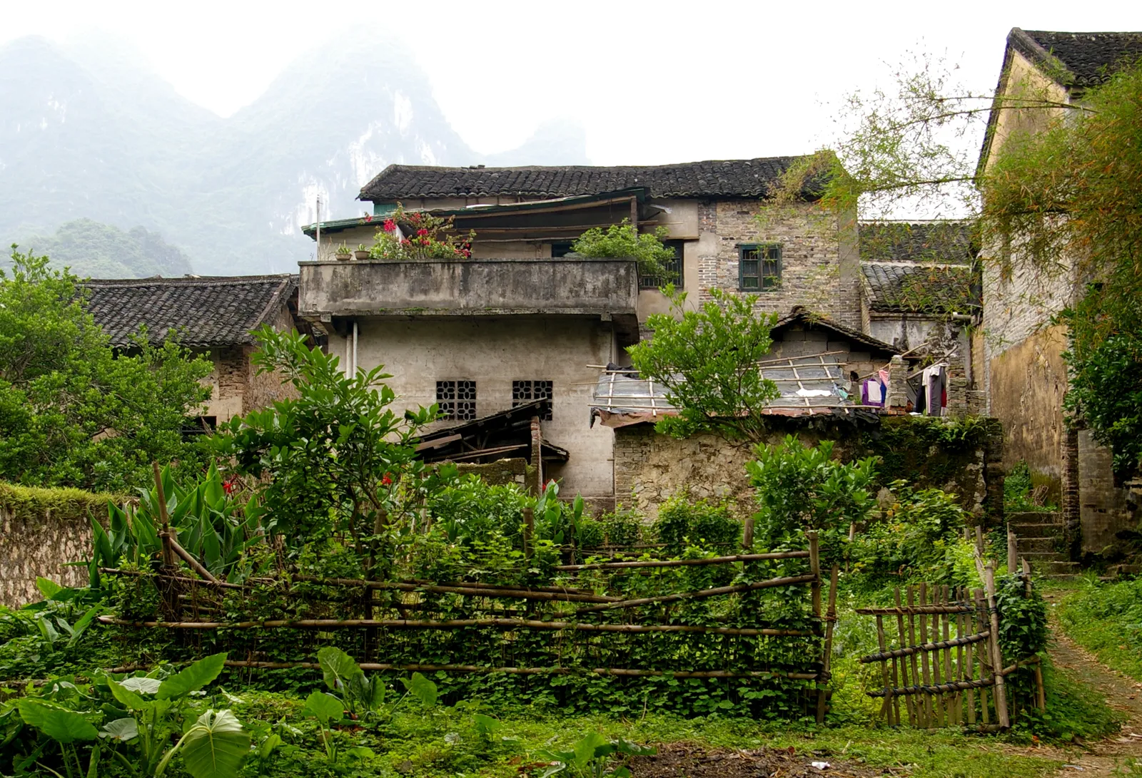 Old village house and gardens in Xingping town below karst peaks