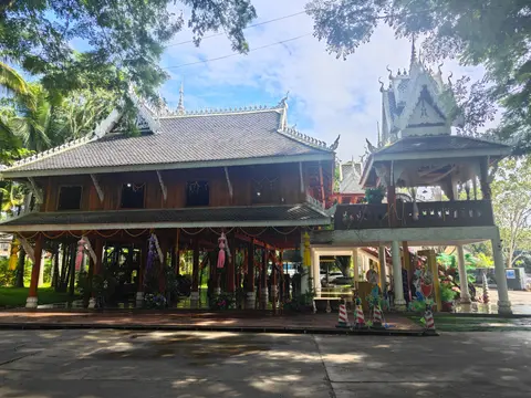 A traditional Dai stilt house beside a temple in the Dai Ethnic Garden