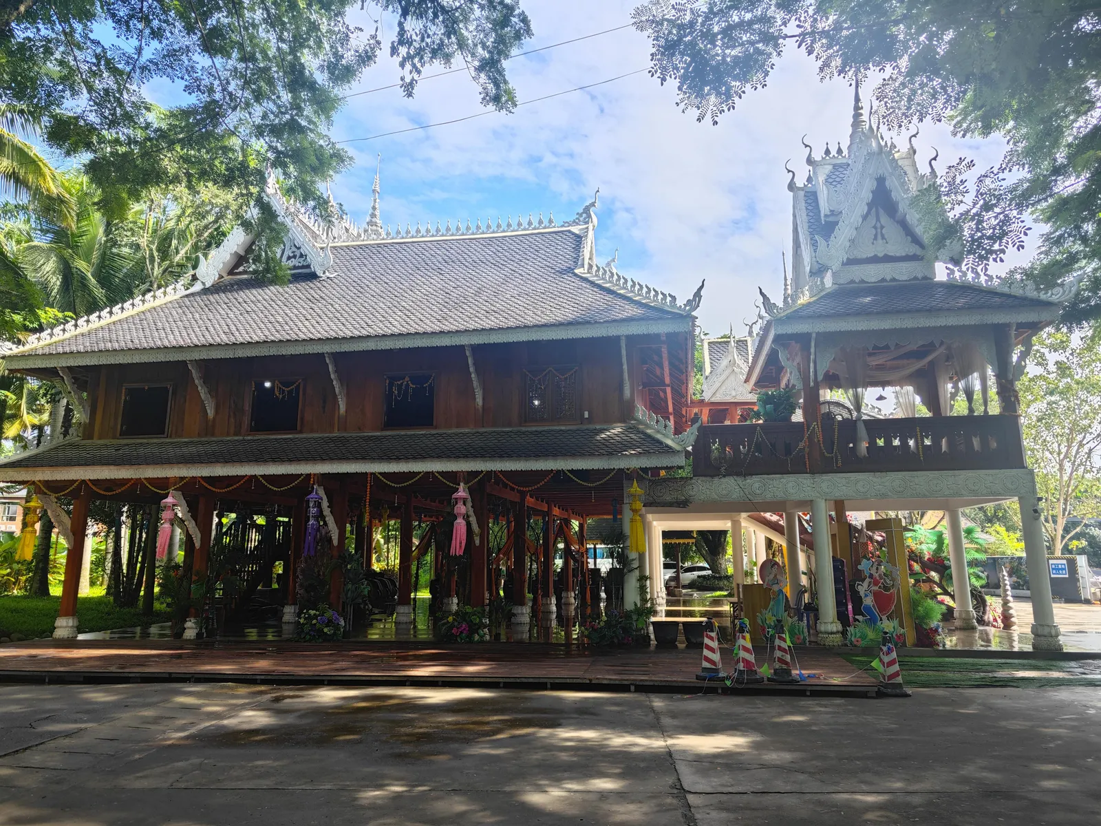 A traditional Dai stilt house beside a temple in the Dai Ethnic Garden