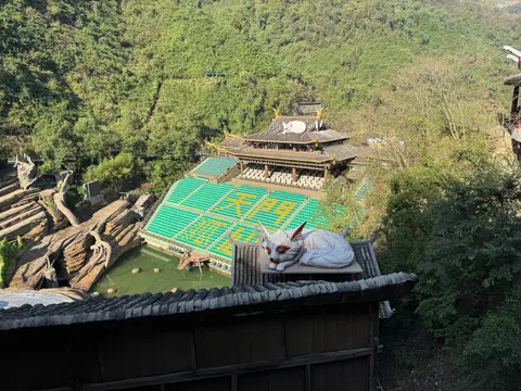 Hillside outdoor theatre of the Tianmen Fox Fairy show by day, with fox statue
