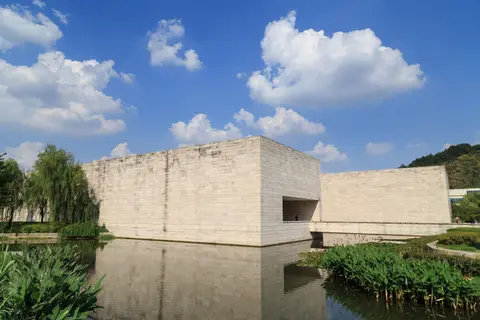 Liangzhu Museum’s stone-clad blocks reflected in its pool