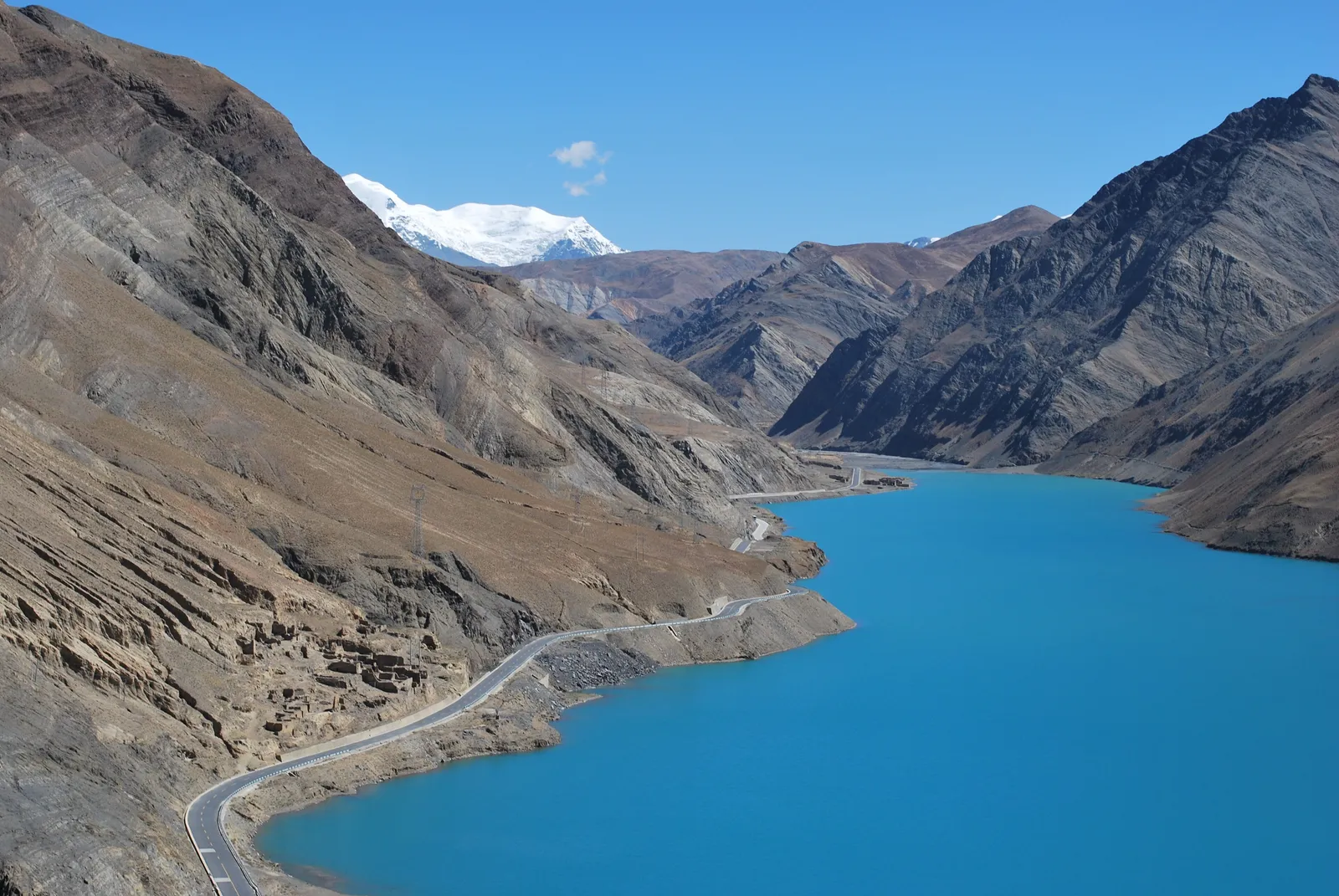 The turquoise waters of Yamdrok Lake between bare mountain slopes