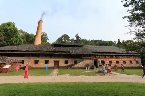 The Qing-dynasty Zhen kiln house with its smoking chimney at the Ancient Kiln Folk Custom Museum