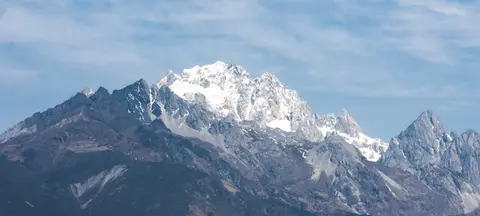 Snow-capped peaks of Jade Dragon Snow Mountain against a blue sky