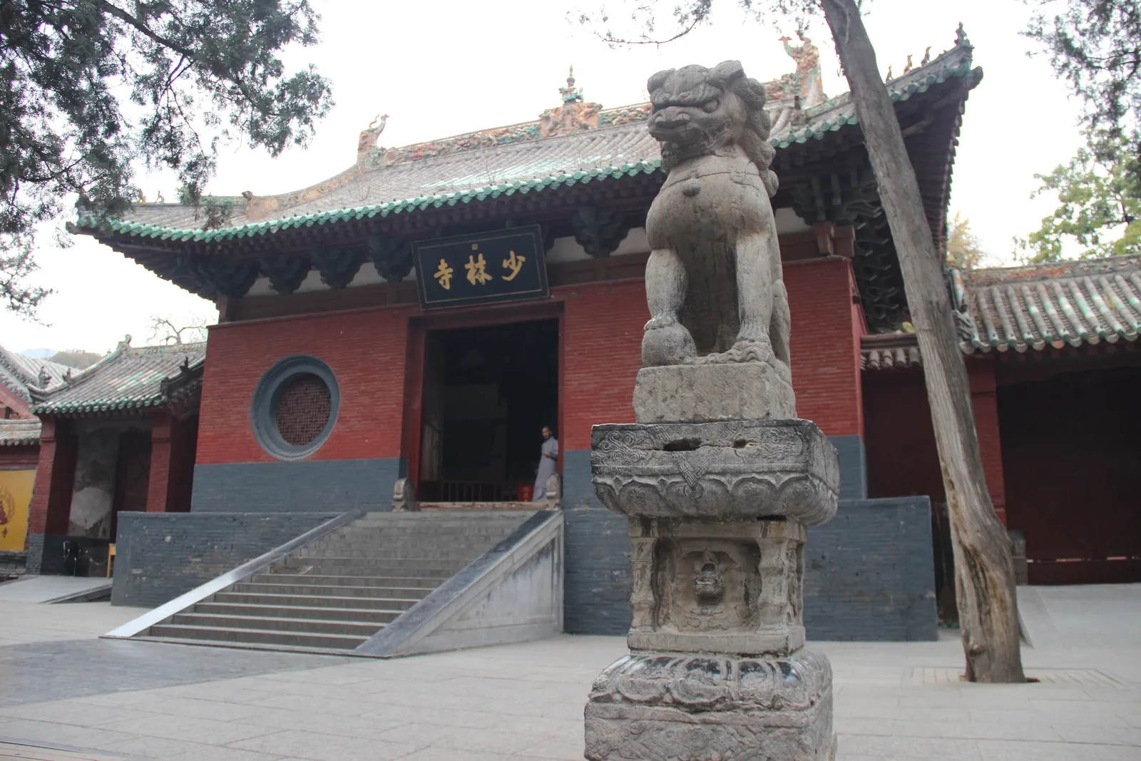 The red mountain gate of Shaolin Temple with a stone lion