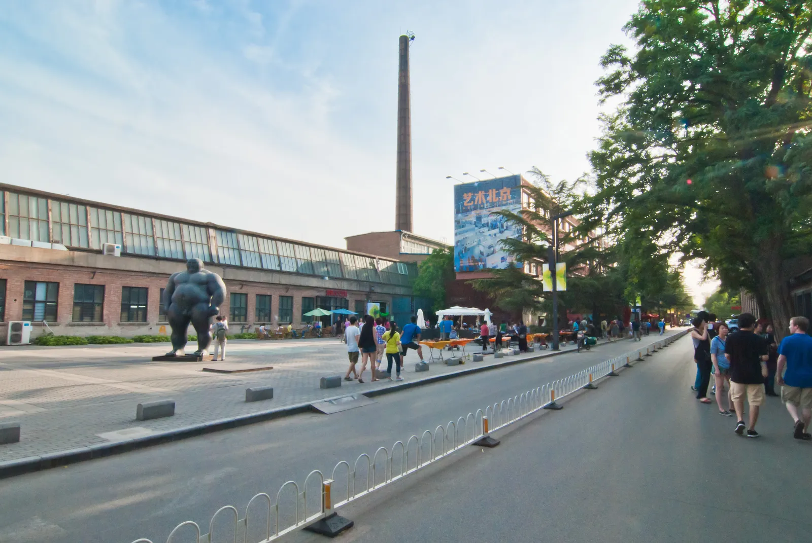 Old factory buildings, chimney and sculpture on a street in the 798 Art District