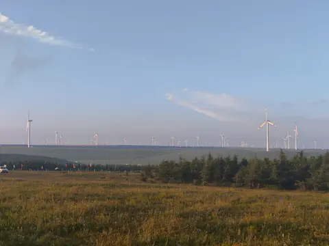 Steppe verte et éoliennes à l’horizon à Huitengxile
