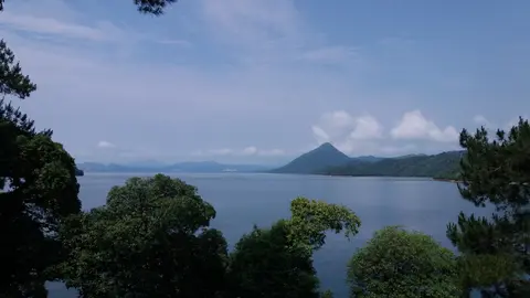 Taiping Lake’s calm water and wooded hills seen through trees