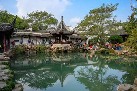 Central pond and pavilion reflected in the Master of the Nets Garden