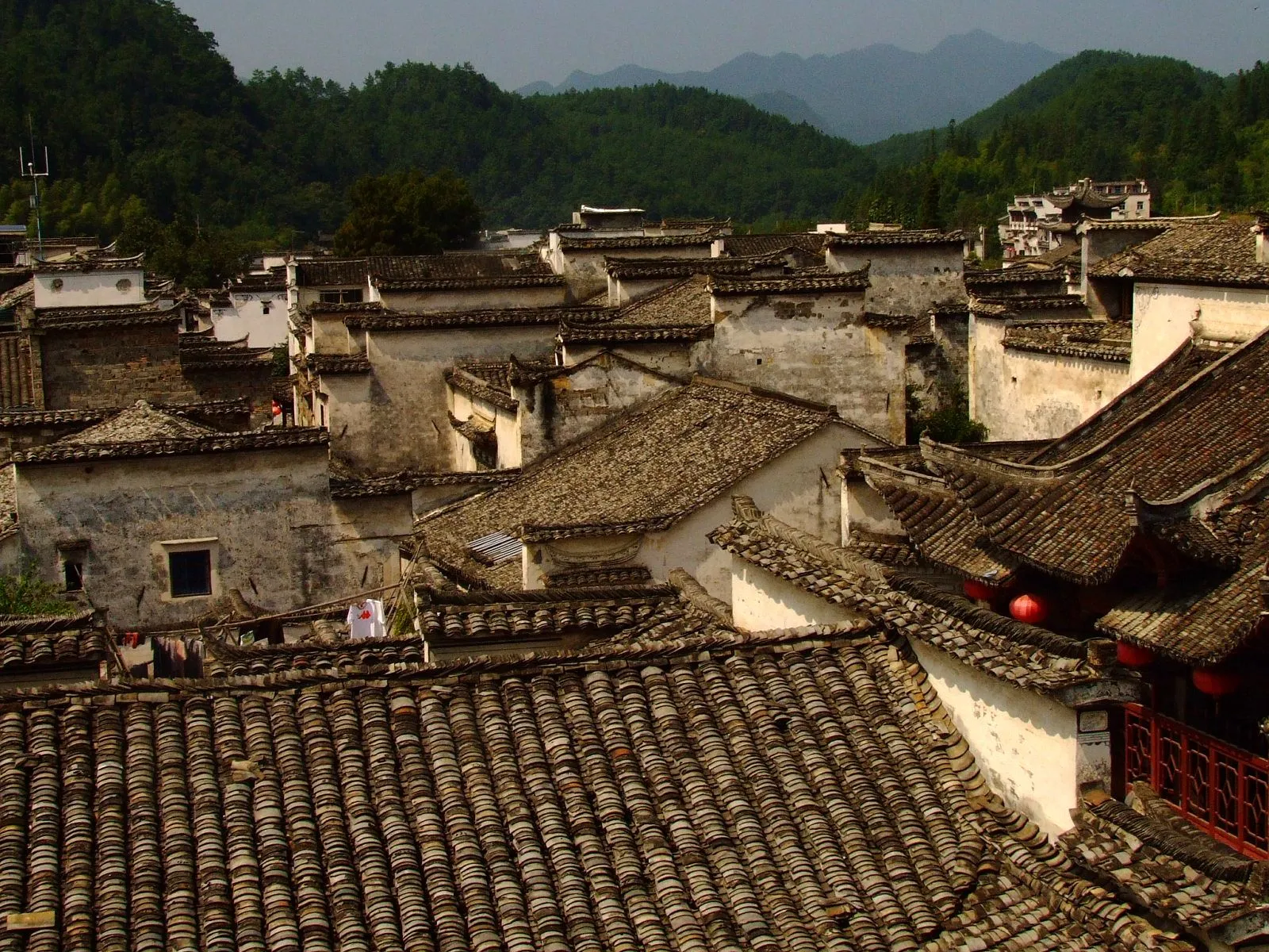 Grey-tiled rooftops of Xidi village against green hills
