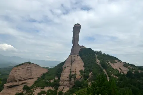 Le pilier rocheux du pic Qingchui sur une crête verdoyante