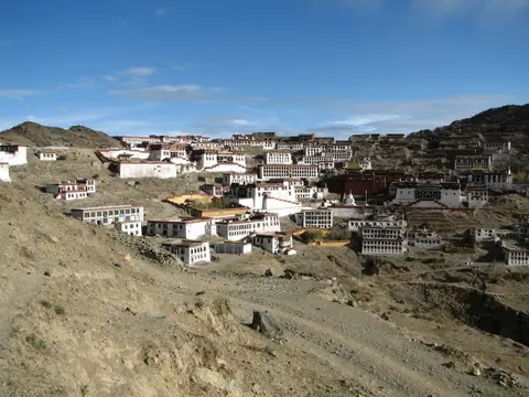 Ganden Monastery's whitewashed buildings spread across a mountain bowl