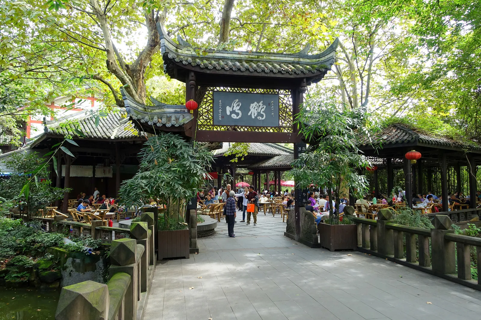 Heming Teahouse gateway and tea tables under trees in People’s Park