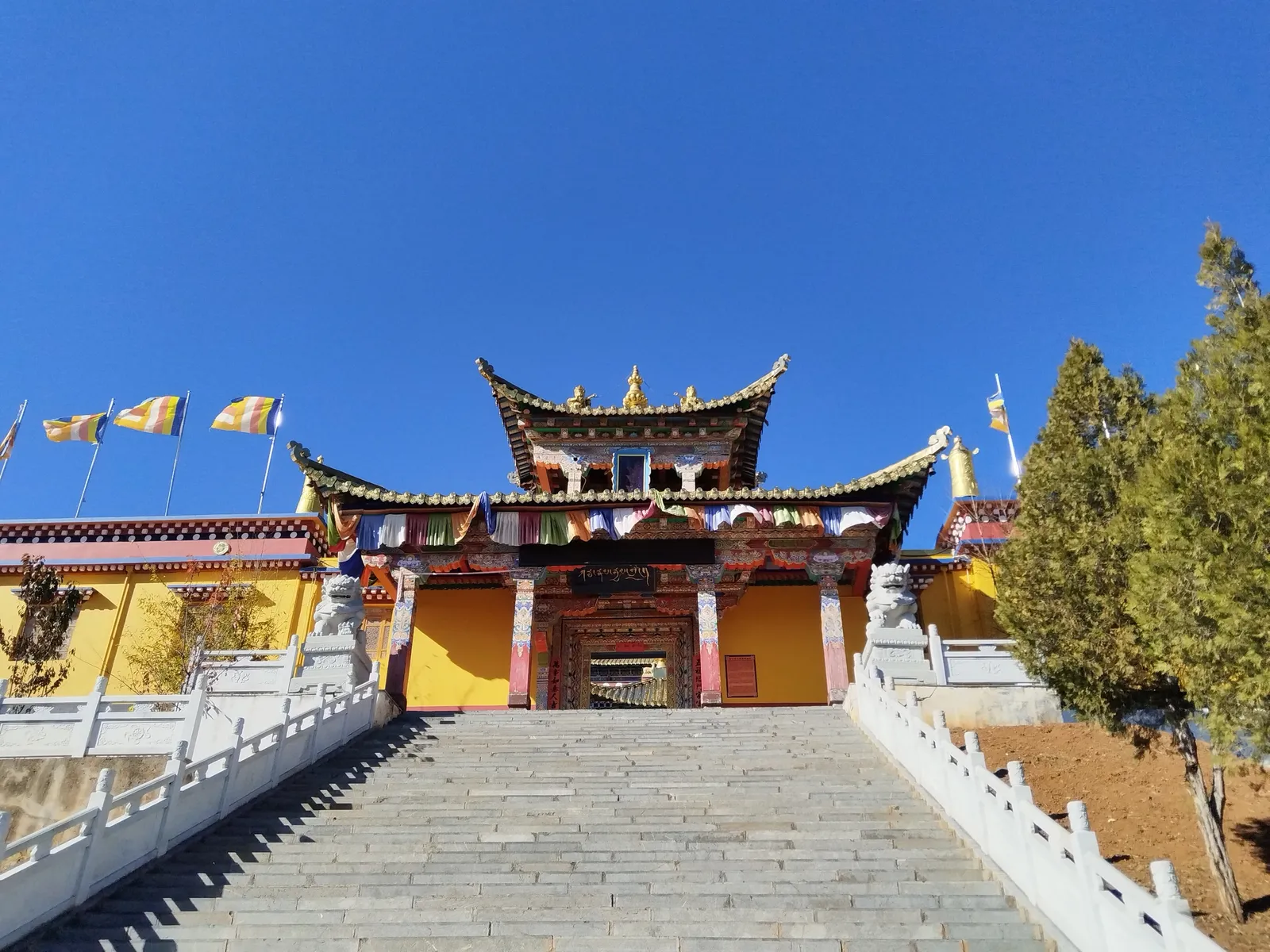 Stairway up to the Tibetan Buddhist halls of Zhiyun Temple under a blue sky