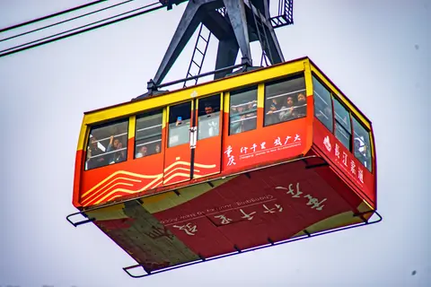 A red Yangtze River Cableway cabin hanging from its cables