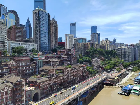 Hongyadong's stilted buildings on the cliff above the Jialing River, with the city skyline
