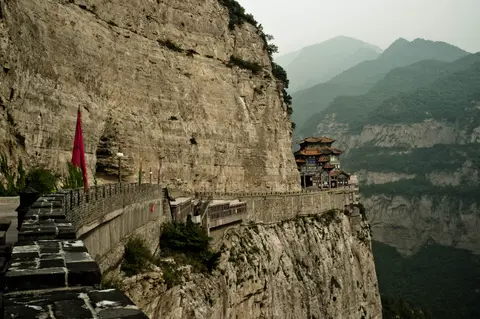 Cliff-hugging walkway and temple on the sheer rock walls of Mount Mian