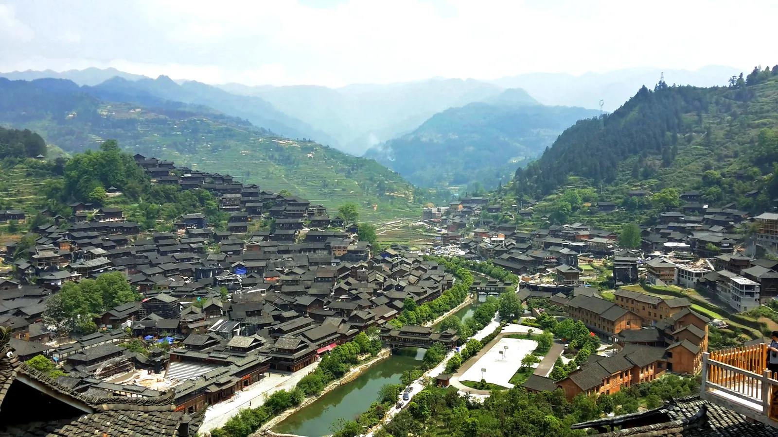 Wooden stilt houses of Xijiang Miao Village covering the hillsides along the river valley