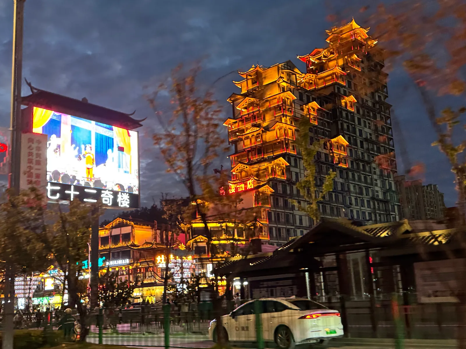 The 72 Qilou tower complex lit up in gold at dusk in Zhangjiajie city