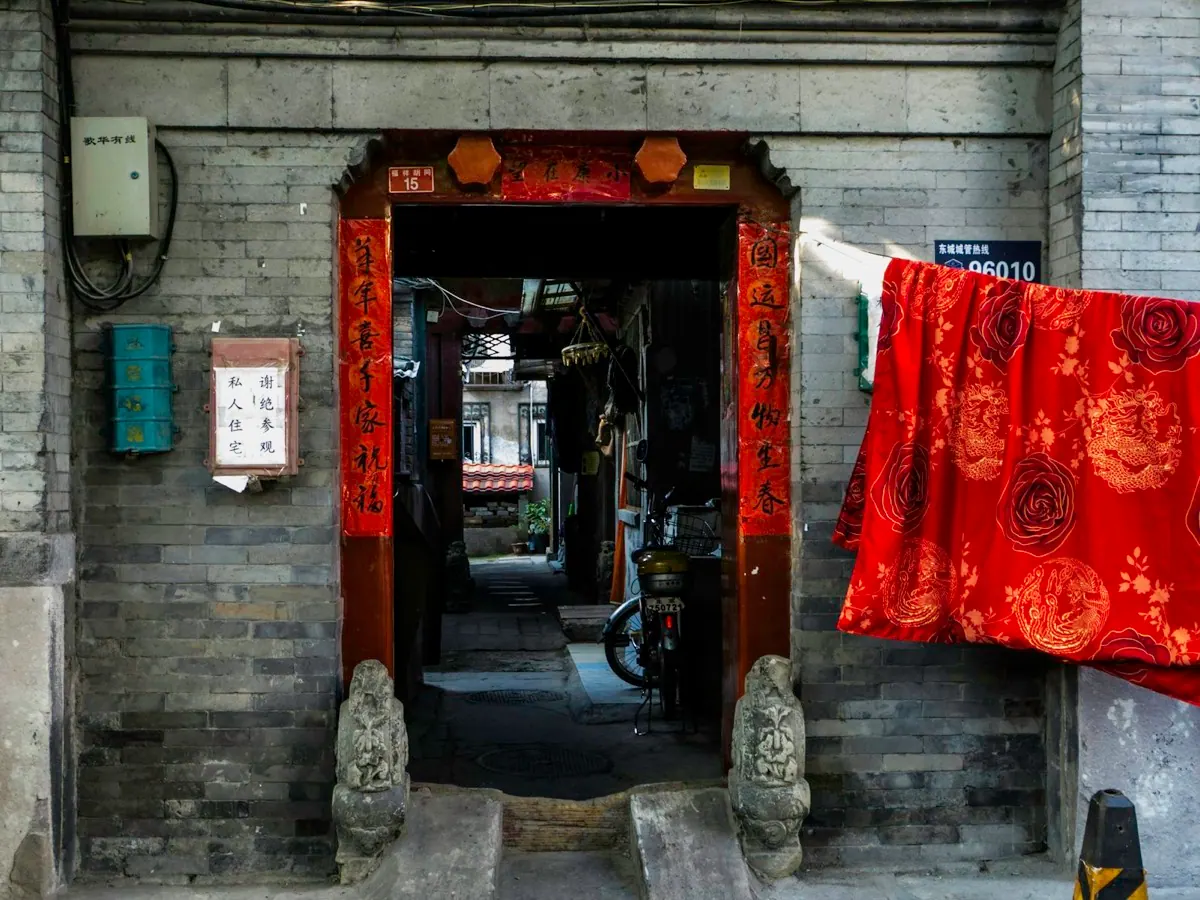 Das rote Tor eines Hofhauses in einem Pekinger Hutong