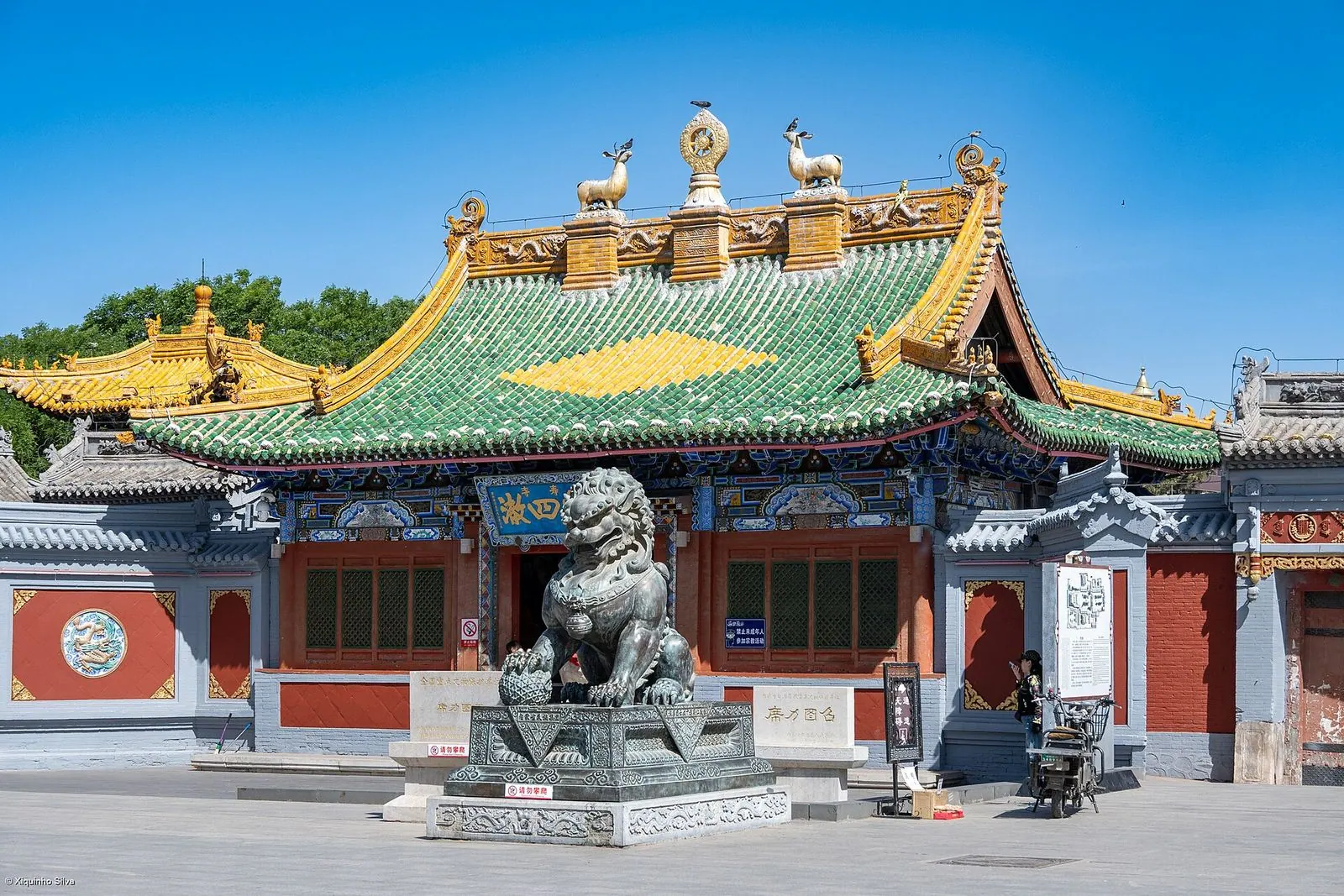 Green-tiled hall and stone lion at Xilitu Zhao monastery in Hohhot