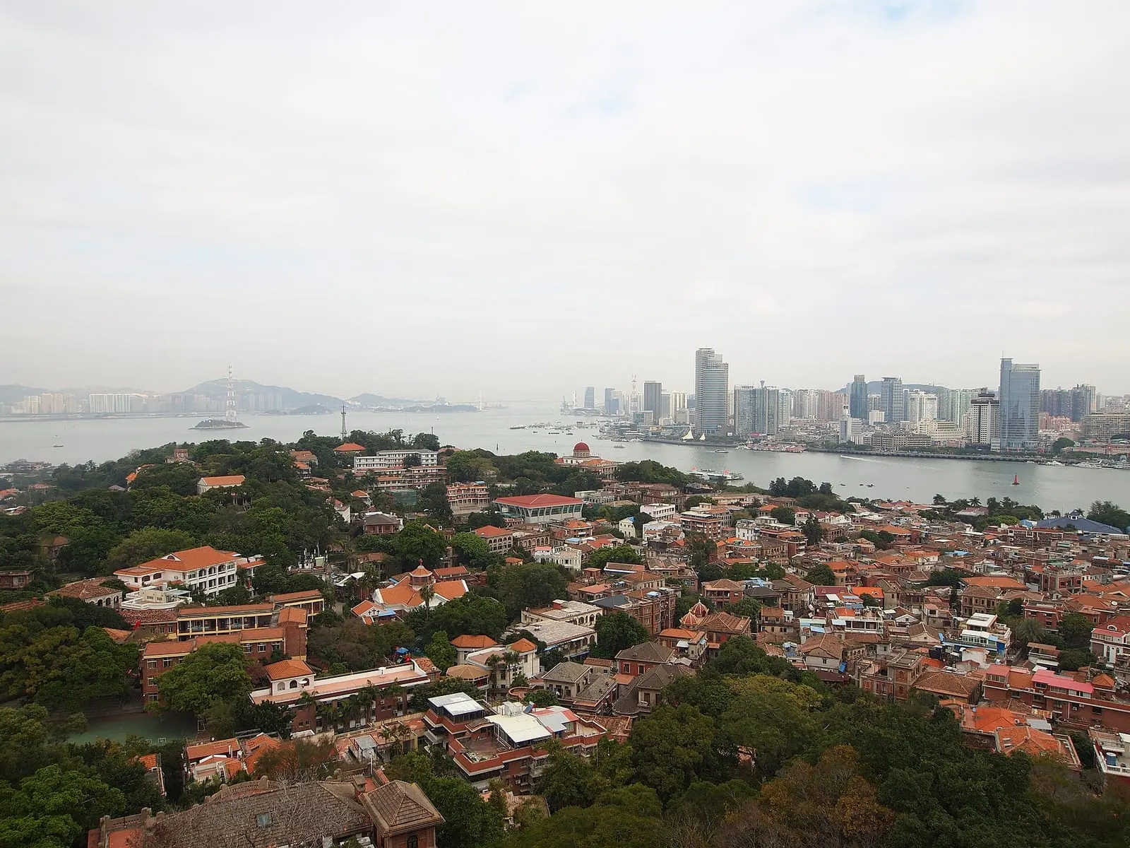 Red roofs of Gulangyu Island with Xiamen skyline across the water