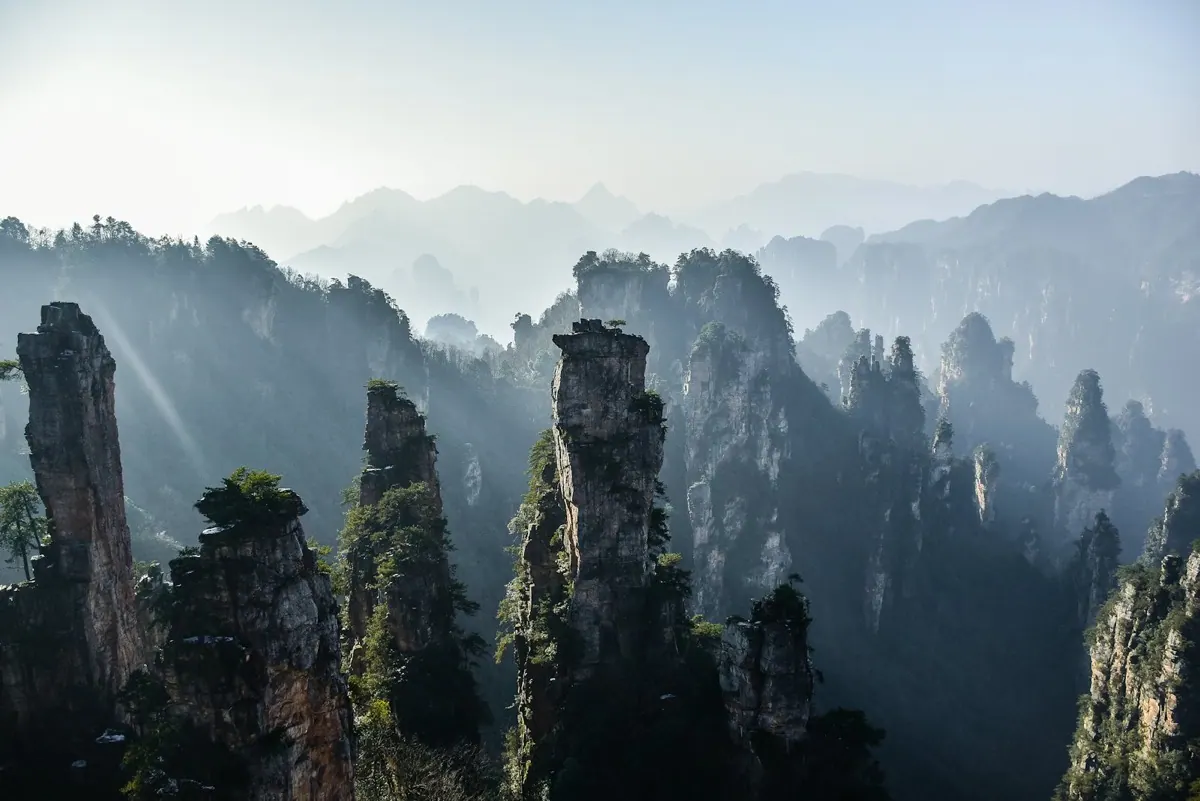 Sandstone pillars rising above a misty valley